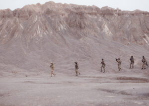 Military burn pit smoke rising in a desert deployment environment.