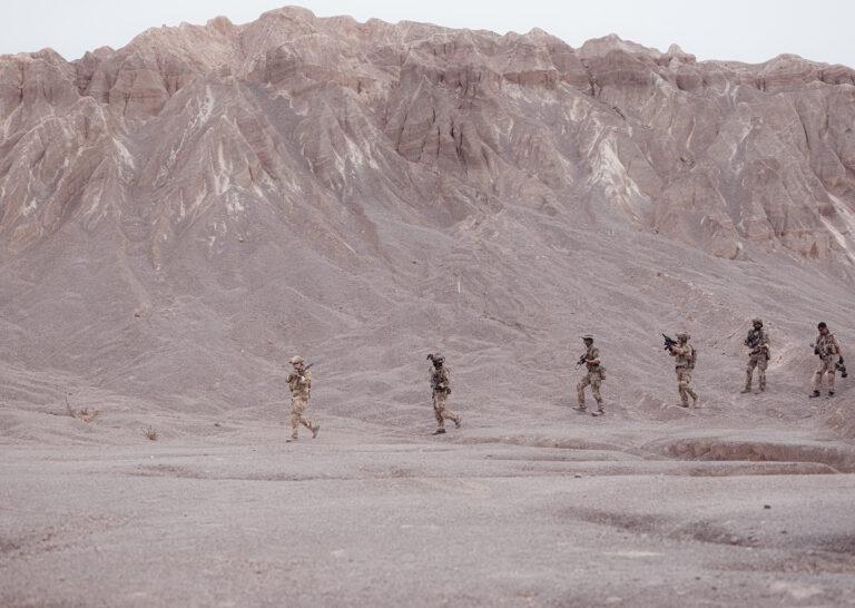 Military burn pit smoke rising in a desert deployment environment.
