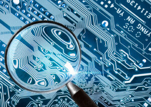 A magnifying glass hovering over a computer circuit board, sharp focus