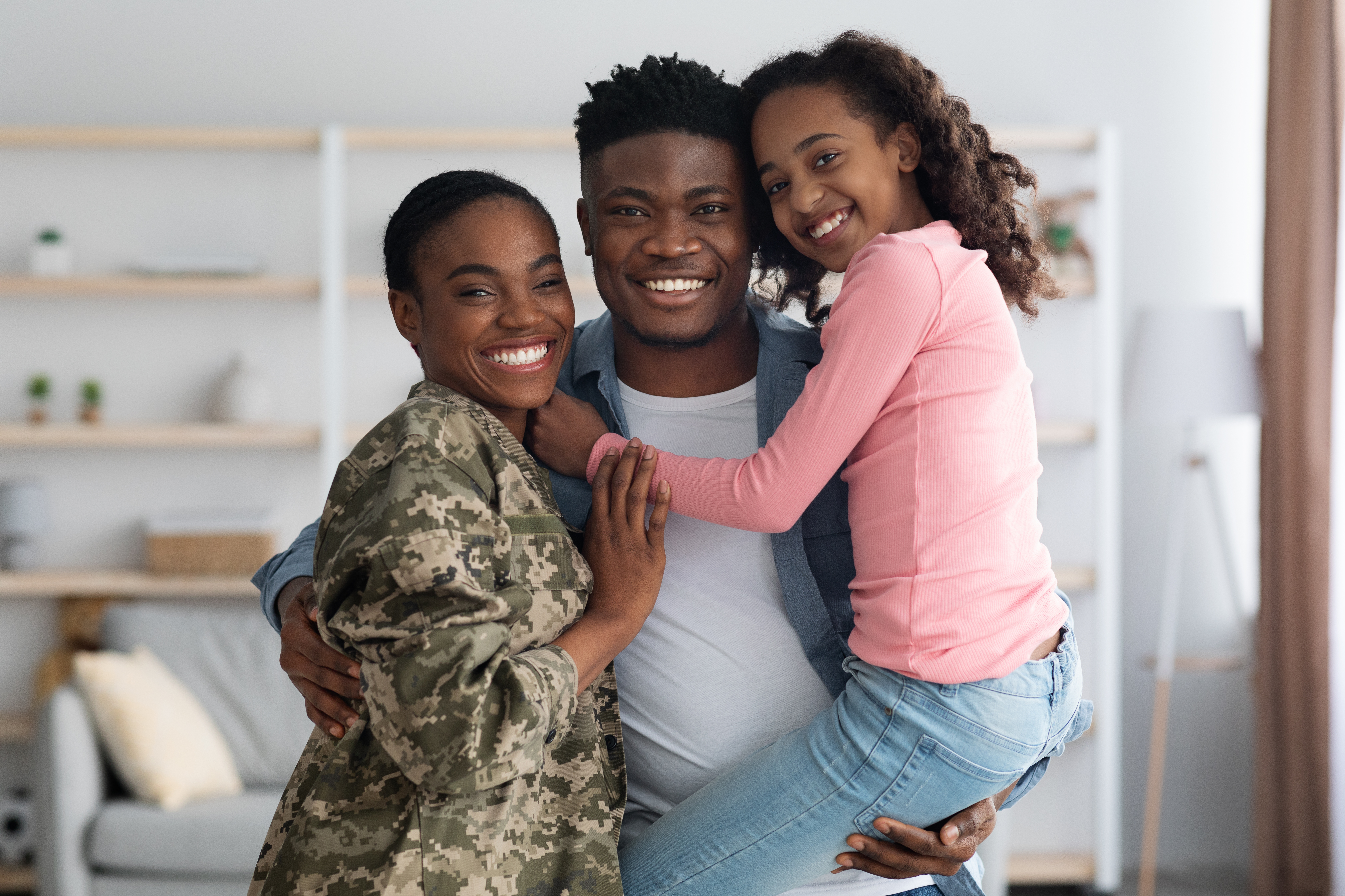 Servicemember in uniform at home with her family, representing veterans keeping their homes through VA mortgage assistance